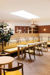 a dining room with tables and chairs and shelves at Maison Arya in Brussels