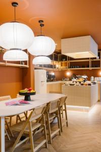 een keuken met een tafel, stoelen en verlichting bij Maison Arya in Brussel