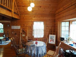 ein Esszimmer mit einem Tisch in einer Blockhütte in der Unterkunft GlampHouse DAISEN Forest - Vacation STAY 30118v in Yonago