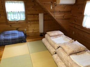 pokój z 2 łóżkami w drewnianym domku w obiekcie GlampHouse DAISEN Forest - Vacation STAY 30118v w mieście Yonago