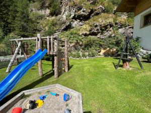 um parque infantil com um escorrega num quintal em Feichterhof em Riva di Tures