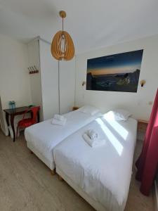 Un dormitorio con una cama blanca con toallas. en Hôtel Les Mouflons en Le Mont-Dore