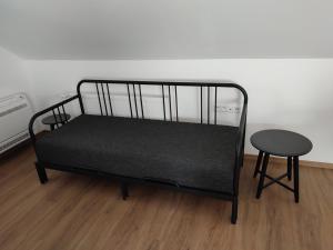 Virthova Pustatina的住宿－apartmánový dom rodiny BÖJTÖS，一张带凳子和桌子的黑婴儿床