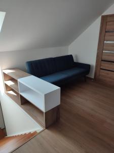 a living room with a blue couch and a table at apartmánový dom rodiny BÖJTÖS in Virthova Pustatina