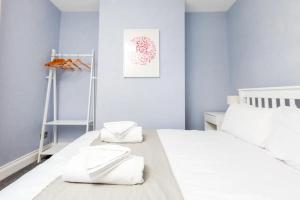 a bedroom with blue walls and a bed with two towels at Modern and Stylish 2 Bedroom House in Brighton in Brighton & Hove