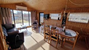 a living room with a table and a dining room at Thingvellir Lake Cottage in Veiðilundur