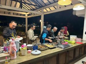 Dewa Daru Resort في كاريمونجاوا: مجموعة من الناس يعدون الطعام في مطبخ