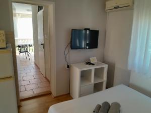 Televízia a/alebo spoločenská miestnosť v ubytovaní Apartmani Sidro
