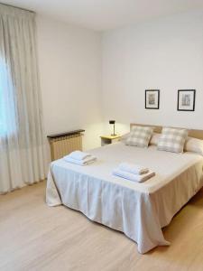 1 dormitorio con 1 cama blanca grande y toallas. en Secrets of Montserrat, en El Bruc