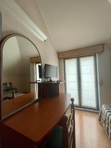 Habitación con mesa, espejo y cama. en Hotel La Pergola, en Rionero in Vulture