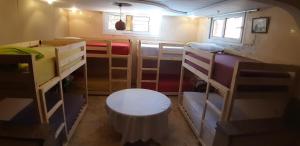 a room with several bunk beds and a table at Mubaradise Surf Hostel in Imsouane
