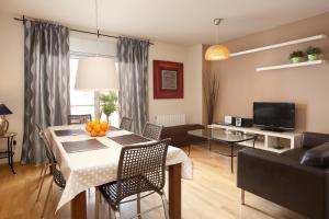 a living room with a dining room table and a couch at RAMBLA BEACH Barcelonastuff Apartments in Barcelona