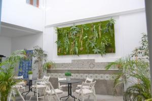 a living wall in a restaurant with tables and chairs at SunShine Barroso Centro in Córdoba