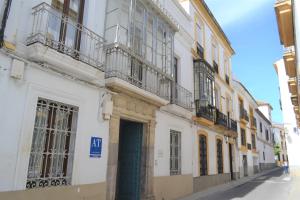 een wit gebouw met een blauwe deur op een straat bij SunShine Barroso Centro in Córdoba