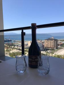 uma garrafa de vinho e dois copos numa mesa em Paradise Dream 3 Apartment in Vlora em Vlorë
