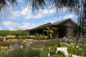 a garden with flowers in front of a house at Petit Verdot Cottage - A Vineyard Retreat in Barossa Valley in Rowland Flat