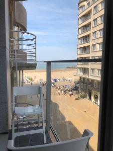 a balcony with a chair and a view of a beach at Modern apartment at 2 steps from beach in Ostend