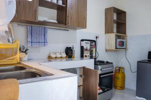 a kitchen with a sink and a stove at MORNINGSTAR 2BR APARTMENTS IN NAKURU in Nakuru