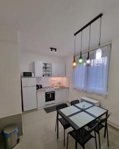 eine Küche mit einem Tisch und Stühlen im Zimmer in der Unterkunft Barcika Apartman in Kazincbarcika