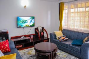 a living room with two couches and a tv at MORNINGSTAR 2BR APARTMENTS IN NAKURU in Nakuru