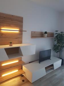 a room with a white desk with a tv on it at Green apartament in Şelimbăr