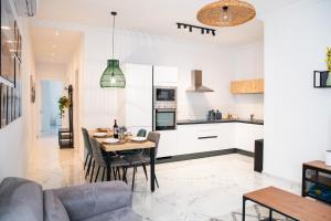 eine Küche und ein Wohnzimmer mit einem Tisch und einem Sofa in der Unterkunft Sliema 2BR Backyard Flat by Arco Collection in Sliema
