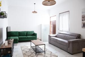 - un salon avec un canapé vert et une table dans l'établissement Sliema 2beds Backyard Flat, à Sliema