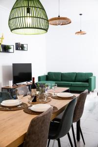 stół jadalny z krzesłami i zieloną kanapą w obiekcie Sliema 2beds Backyard Flat w mieście Sliema