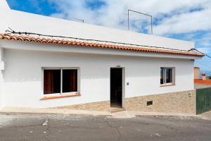 ein weißes Haus mit einer schwarzen Tür in der Unterkunft La casa de Amalia in Garachico
