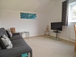 a living room with a couch and a flat screen tv at Orchard View B&B in Whitminster