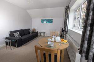 a living room with a table and a couch at Orchard View B&B in Whitminster
