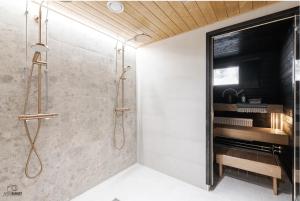 La salle de bains est pourvue d'une douche avec une porte en verre. dans l'établissement Kingwest Villa - free parking, sauna & 5 bedrooms, à Tampere
