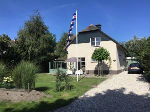 a house with a flag on the side of it at Duinvilla met sauna en whirlpool in Makkum