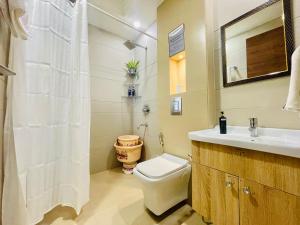 a white bathroom with a toilet and a sink at Bedchambers Serviced Apartments, Ardee City in Gurgaon +31 photos