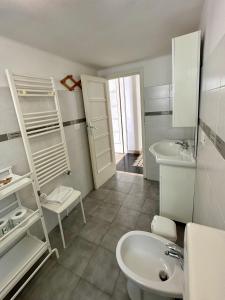 a white bathroom with a sink and a toilet at Appartamento Via Trevisani in Bari