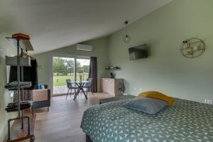 a bedroom with a bed and a kitchen with a table at Pronkserf in Lemelerveld