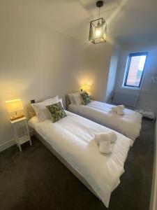 2 camas blancas en una habitación con ventana en Stylish City Centre Flat, en Norwich