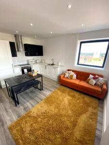 a living room with an orange couch and a table at Stylish City Centre Flat in Norwich