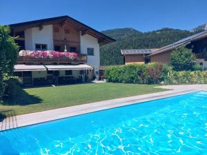 una villa con piscina di fronte a una casa di Appartement Unterbering a Söll