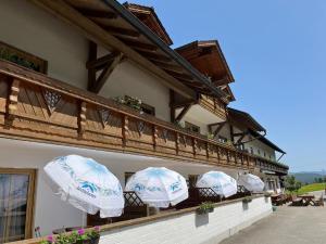three white umbrellas on a balcony of a building at Landgasthof Blasini - Pfahlhof in Zandt