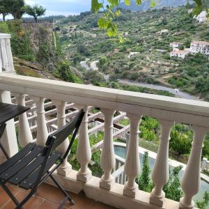 a chair on a balcony with a view of a valley at Hostal El Cerro - Only Adults in Pedro Bernardo