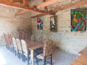 a dining room with a wooden table and chairs at Le Couche t'Art in Pisseloup