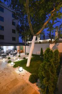 a tree in the middle of a courtyard with a building at İSTPORT GARDEN HOTELS in Arnavutköy