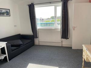 uma sala de estar com um sofá e uma janela em Lovely 2 bedrooms apartment West derby Liverpool em Deysbrook