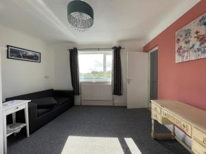 - un salon avec un canapé et une fenêtre dans l'établissement Lovely 2 bedrooms apartment West derby Liverpool, à Deysbrook