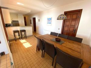 cocina y comedor con mesa de madera y sillas en Spectacular Mediterranean view! en Palafrugell