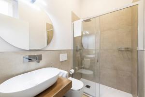 een badkamer met een witte wastafel en een spiegel bij B&B De I Bravi in Cormano