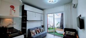 een woonkamer met een bank en een glazen schuifdeur bij Oasis Marin 1 Studio Proche Mer in Cagnes-sur-Mer
