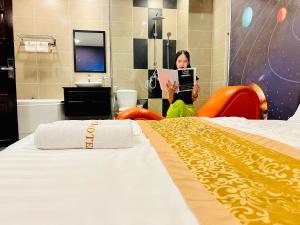 a woman in a hotel room with two beds at ONE HOTEL in Vĩnh Long