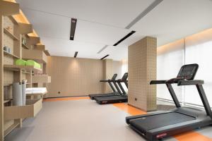 a gym with several treadmills and a row of treadms at Home2 Suites by Hilton Beijing West Station in Beijing